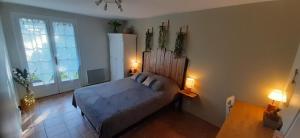 ein Schlafzimmer mit einem Bett, einem Fenster und zwei Lampen in der Unterkunft Le Pressoir in Cresseveuille