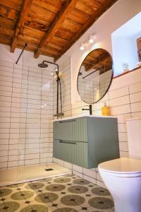 ein Bad mit einem WC und einem Spiegel in der Unterkunft Finca La Casería LA CASA in Cangas de Onís