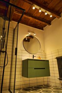La salle de bains est pourvue d'un lavabo vert et d'un miroir. dans l'établissement Finca La Casería LA CASA, à Cangas de Onís