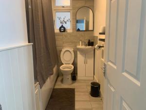La petite salle de bains est pourvue de toilettes et d'un lavabo. dans l'établissement L A PLACE Croydon, London, à Norwood