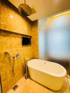 uma banheira na casa de banho com uma janela em Dorsett Suites City Center KL em Kuala Lumpur