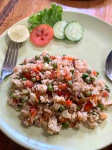 a plate of food with rice and vegetables on a table at kohkoodfarmstay in Ban Ao Yai