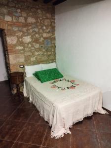 Bett in einem Zimmer mit Ziegelwand in der Unterkunft La taverna sotto la torre in Massa Marittima