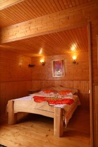 a bed in a wooden room in a cabin at Котедж у Карпатах in Tukholʼka