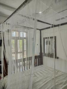 a bedroom with a bed covered in white mosquito nets at River Relax Villa in Ahangama