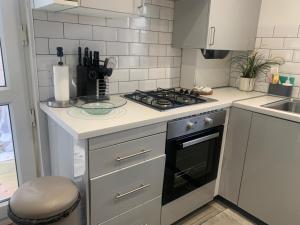 a kitchen with a stove top oven next to a sink at L A PLACE Croydon, London in Norwood