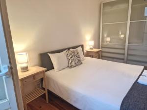 um quarto com uma cama branca e duas mesas de cabeceira em Avenida Terrace em Lisboa