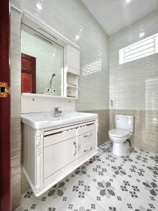 a white bathroom with a sink and a toilet at Căn hộ mới - 4 Phòng ngủ lớn tại Khu Biệt Thự Nam Long- Bê Tông Residences in Cái Răng