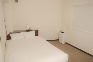 Un pat sau paturi într-o cameră la HOTEL G-CUE 大阪谷町