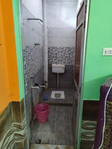 a small bathroom with a toilet and a bucket at Hotel Omni Palace By BookingCare in Murera