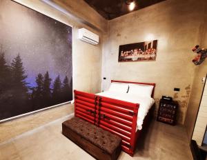 a bedroom with a red bed and a large painting on the wall at Noah's Ark Homestay in Huxi