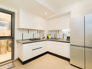 una cucina bianca con armadi bianchi e una finestra di Aira Residence - 2nd Floor 1007 a Hulhumale