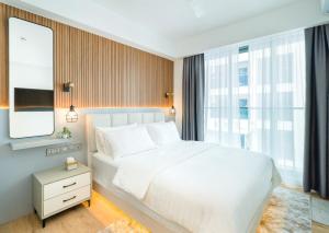 una camera con un letto bianco e una grande finestra di Aira Residence - 2nd Floor 1007 a Hulhumale
