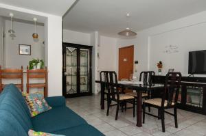 ein Wohnzimmer mit einem Tisch und einem blauen Sofa in der Unterkunft Lory's House - 400mt dal mare in Donnalucata