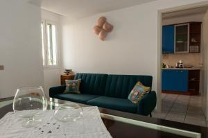 ein Wohnzimmer mit einem grünen Sofa und einem Glastisch in der Unterkunft Lory's House - 400mt dal mare in Donnalucata