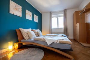 a bed in a room with a blue wall at Doppelhaus- Villa Leipzig Schleußig , moderner Altbau Apartment Dachetage mit 2 Schlafzimmern und separatem Zusatzzimmer , Parkplatz - Balkon - Kamin - Eicheparkett - Arbeitsplatz in Leipzig