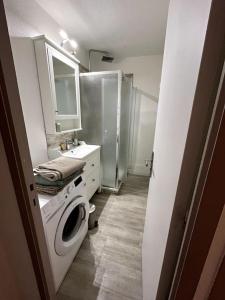 a bathroom with a washing machine and a shower at Le Refuge Marin in Courseulles-sur-Mer