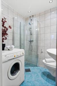 uma máquina de lavar roupa na casa de banho com um chuveiro em Charming and cozy - 5 min to city center - 5 pers em Oslo