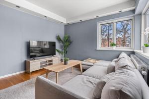 uma sala de estar com um sofá e uma televisão em Charming and cozy - 5 min to city center - 5 pers em Oslo
