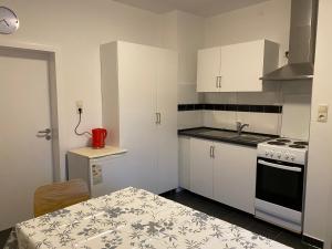 a small kitchen with white cabinets and a table with a red appliance at Wohnung für bis zu 4 Personen in Ludwigshafen am Rhein