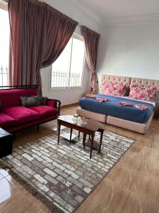 a living room with a bed and a couch and a table at Riad Ras Lafaa in Safi