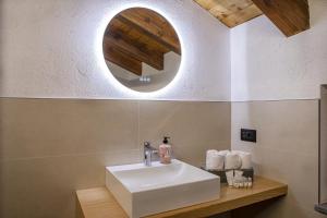 a bathroom with a white sink and a mirror at Lo Stambecco Bianco Chalet in Aosta