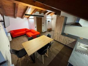 a living room with a wooden table and a red couch at Lo Stambecco Bianco Chalet in Aosta