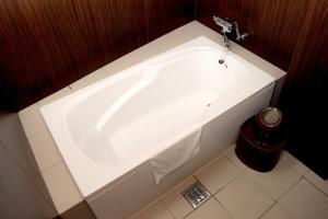 a bath tub in a bathroom with a sink at HOTEL G-CUE 大阪谷町 in Osaka