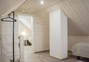 a bedroom in a attic with a bed and a doorway at Särkisalon Villa Albin in Särkisalo
