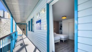 a room with a bed and a balcony at Hotel De La Gare in Quimper