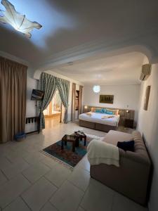 un ampio soggiorno con un letto e un divano di Riad Ras Lafaa a Safi