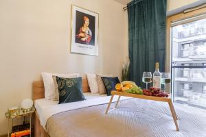 a bedroom with a bed with a tray of fruit on it at Lumina premium apart with parking, balcony near Palace of Culture and Science in Warsaw