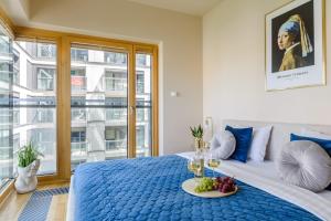 a bedroom with a blue bed with a tray of fruit on it at Lumina premium apart with parking, balcony near Palace of Culture and Science in Warsaw