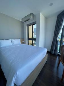 een slaapkamer met een groot wit bed en een raam bij JOYCE HOUSE in Quy Nhon