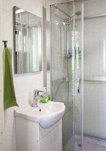 a white bathroom with a sink and a shower at Särkisalon Villa Albin in Särkisalo