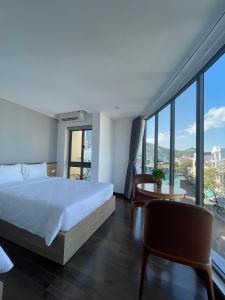 een hotelkamer met een bed en een groot raam bij JOYCE HOUSE in Quy Nhon