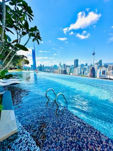 a swimming pool with a city skyline in the background at Dorsett Suites City Center KL in Kuala Lumpur