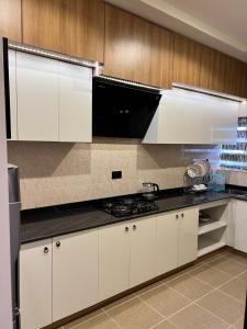 阿布賈的住宿－States Apartment，厨房配有白色橱柜和炉灶烤箱。