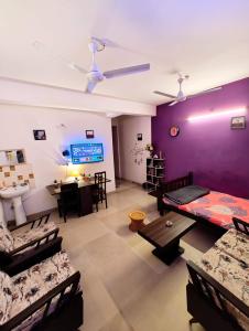 - un salon avec des murs violets et des canapés dans l'établissement Raga Homestay 2BHK- A homely guesthouse experience, à Guwahati