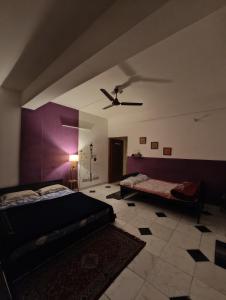 Cette chambre comprend deux lits et un ventilateur de plafond. dans l'établissement Raga Homestay 2BHK- A homely guesthouse experience, à Guwahati