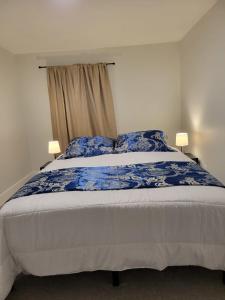 1 dormitorio con 1 cama grande con sábanas azules y blancas en Furnished rooms close to U of A in Edmonton, en Edmonton