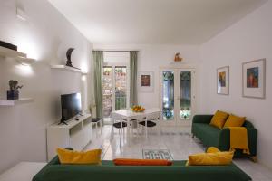 een woonkamer met een groene bank en een televisie bij SARA GUEST HOUSE TAORMINA in Taormina
