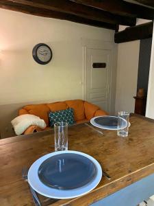 two plates on a wooden table in a living room at Gîte des Moriers Blois Bord de Loire in Blois
