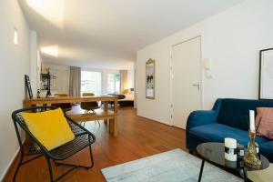 sala de estar con sofá azul y mesa en NEW 4p renovated apartment @BEST location Jordaan en Ámsterdam