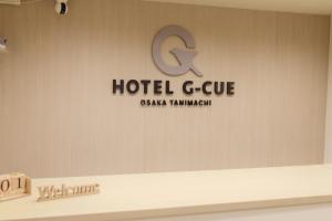 a sign for a hotel c suite on a wall at HOTEL G-CUE 大阪谷町 in Osaka