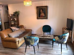 ein Wohnzimmer mit einem Sofa und 2 Stühlen in der Unterkunft La Boissette d’en O in Montgenèvre