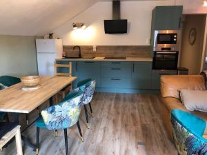eine Küche mit einem Tisch, Stühlen und einem Sofa in der Unterkunft La Boissette d’en O in Montgenèvre