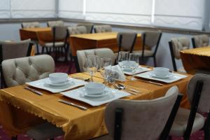 a table with plates and glasses on top at Grand Clover Otel in Seyhan