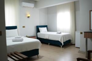 a hotel room with two beds and a window at Grand Clover Otel in Seyhan