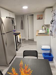 cocina con nevera y mesa. en Furnished rooms close to U of A in Edmonton, en Edmonton